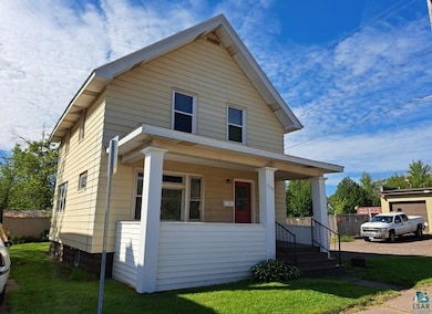 Bungalow-style home with a front yard and covered 