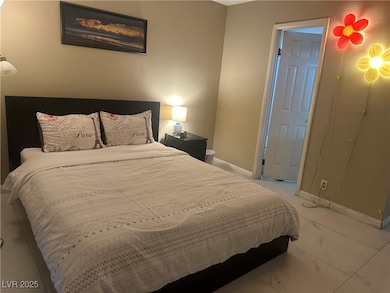 Bedroom with marble finish floor and baseboards