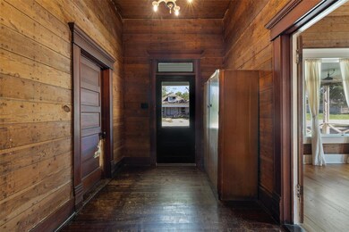 Hallway with wooden walls and dark wood-style flo
