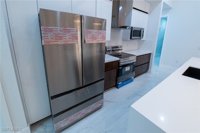 Kitchen with dark brown cabinetry, white cabinets,