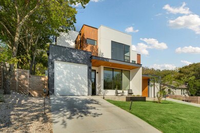 Contemporary home featuring driveway, a front yar