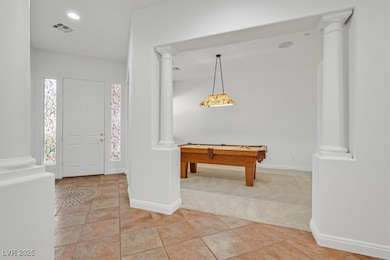 Entryway featuring decorative columns, baseboards,