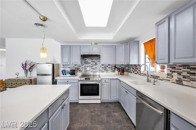 Kitchen with stainless steel appliances, gray cabi