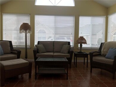 Sun room with tile floor, windows all around, Cathedral ceiling, ceiling fan.