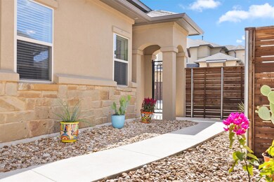 View of exterior entry with fence, stone siding, 