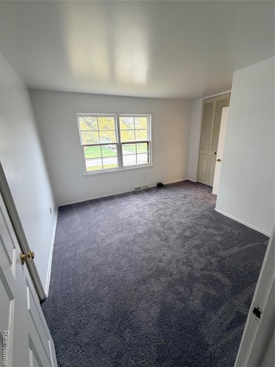Carpeted empty room with baseboards