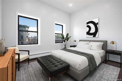 Bedroom featuring baseboard heating, dark wood-type flooring, and recessed lighting