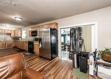 Kitchen featuring black appliances, light countert
