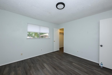 Unfurnished bedroom with dark wood-type flooring,