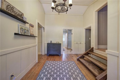 Hall featuring light wood-style flooring, a chande
