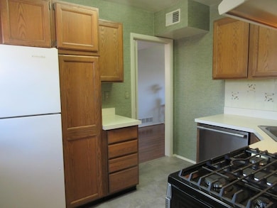 Kitchen with visible vents, freestanding refrigera