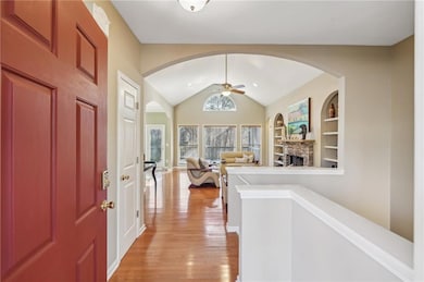 Entryway featuring ceiling fan, a stone fireplace,