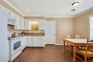 Kitchen featuring white appliances, a sink, white