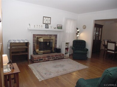 Living room has wood burning brick fireplace with