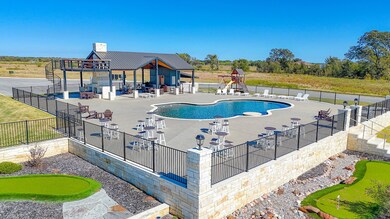 View of swimming pool featuring a patio and view of scattered trees