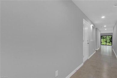 Corridor featuring baseboards and recessed lightin