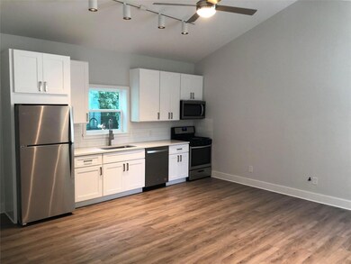 Kitchen with dark wood-style flooring, light coun