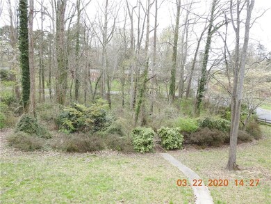 Mature plantings and path into woods to creek