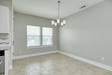 Unfurnished dining area featuring light tile patterned flooring and a chandelier
