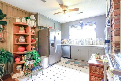 Kitchen with appliances with stainless steel finishes, gray cabinetry, ceiling fan, light flooring, and a sink