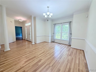 Unfurnished room featuring a chandelier, light woo