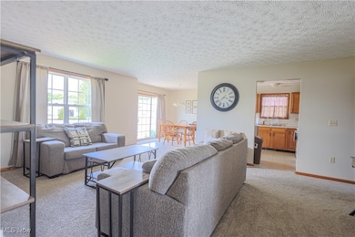 Living room with a textured ceiling, light tile patterned floors, and sink