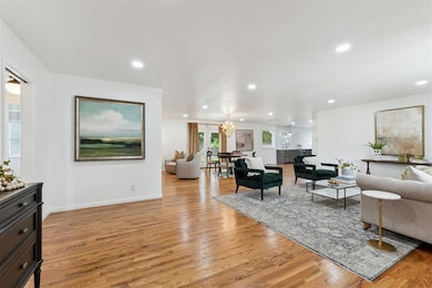 Living room featuring light wood finished floors, recessed lighting, and a chandelier