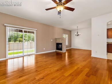 Unfurnished living room with light wood finished floors, a fireplace, a ceiling fan, and a chandelier