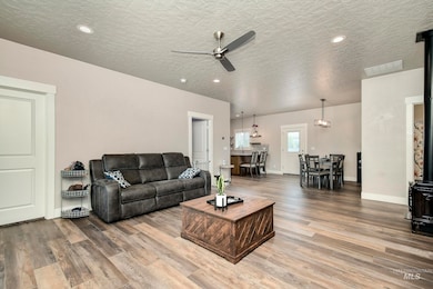 Living area with ceiling fan, wood finished floors, a textured ceiling, and recessed lighting