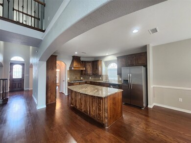 Kitchen with appliances with stainless steel finishes, premium range hood, a wealth of natural light, and a kitchen island