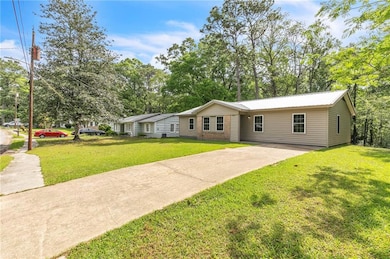 Ranch-style house featuring driveway, a front yard