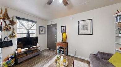 Living area featuring dark wood-style floors, ceil