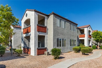 Rear view of house featuring a tile roof, stucco siding, and a balcony