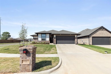 Prairie-style house with driveway, brick siding, a shingled roof, and an attached garage