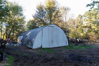 View of outbuilding featuring view of wooded area