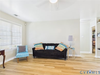 Sitting room featuring light wood-type flooring and ceiling fan