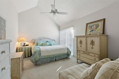 Bedroom featuring lofted ceiling, ceiling fan, a t