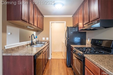 Kitchen featuring gas stove, ornamental molding, under cabinet range hood, light wood finished floors, and dishwashing machine
