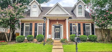 Beautiful traditional home w/covered porch and terraced walkway, sidewalks and gated drive.