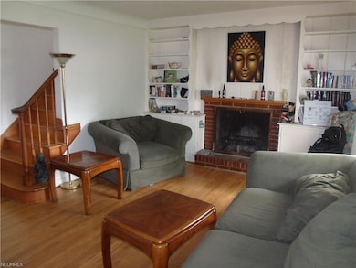 Ample living room with its shiny hardwood floor, woodburning fireplace and built-in bookshelves!