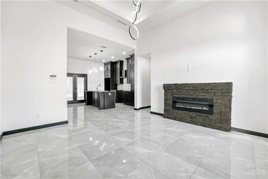 Unfurnished living room featuring french doors, a towering ceiling, a stone fireplace, and sink