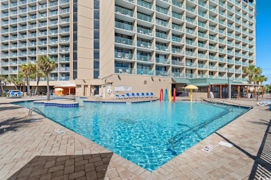 View of swimming pool with a hot tub