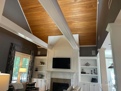 Unfurnished living room featuring built in features, wooden ceiling, and vaulted ceiling