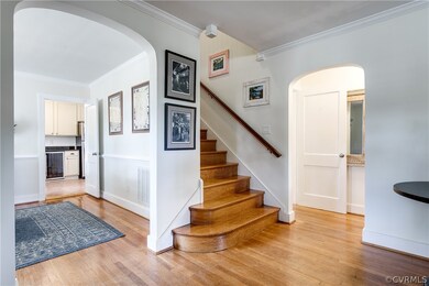 Stairs lead to two upstairs bedrooms and trunk room.  Smaller archway leads to back hall that connects to first floor bedroom (to the right) and utility room and family room (to the left).