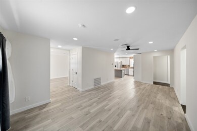 Bright living area featuring wood-look tile flooring & designer light fixtures.