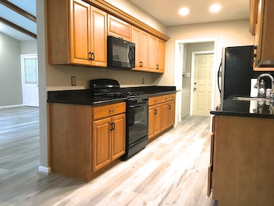 Recently updated kitchen features a gas range and cooktop, microwave, dishwasher and refrigerator.