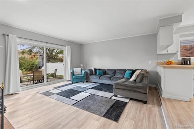 Living room featuring light wood-style flooring and ornamental molding