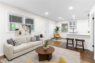 Living room featuring dark wood-type flooring and recessed lighting