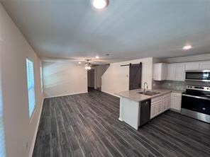 Kitchen with dark wood-style floors, a barn door, 