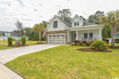 Craftsman house with a garage, a front lawn, stone